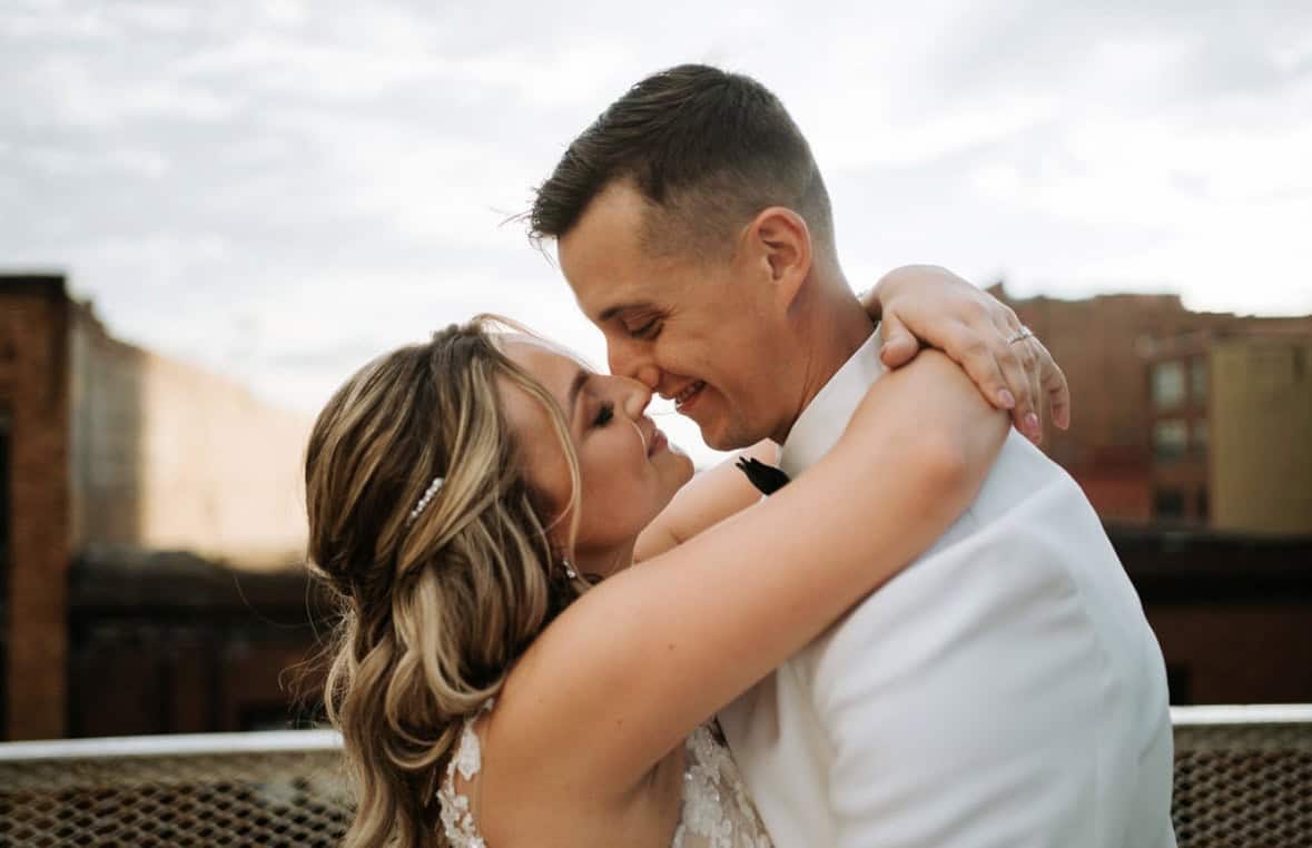 Happy bride and groom embracing outdoors on wedding day.