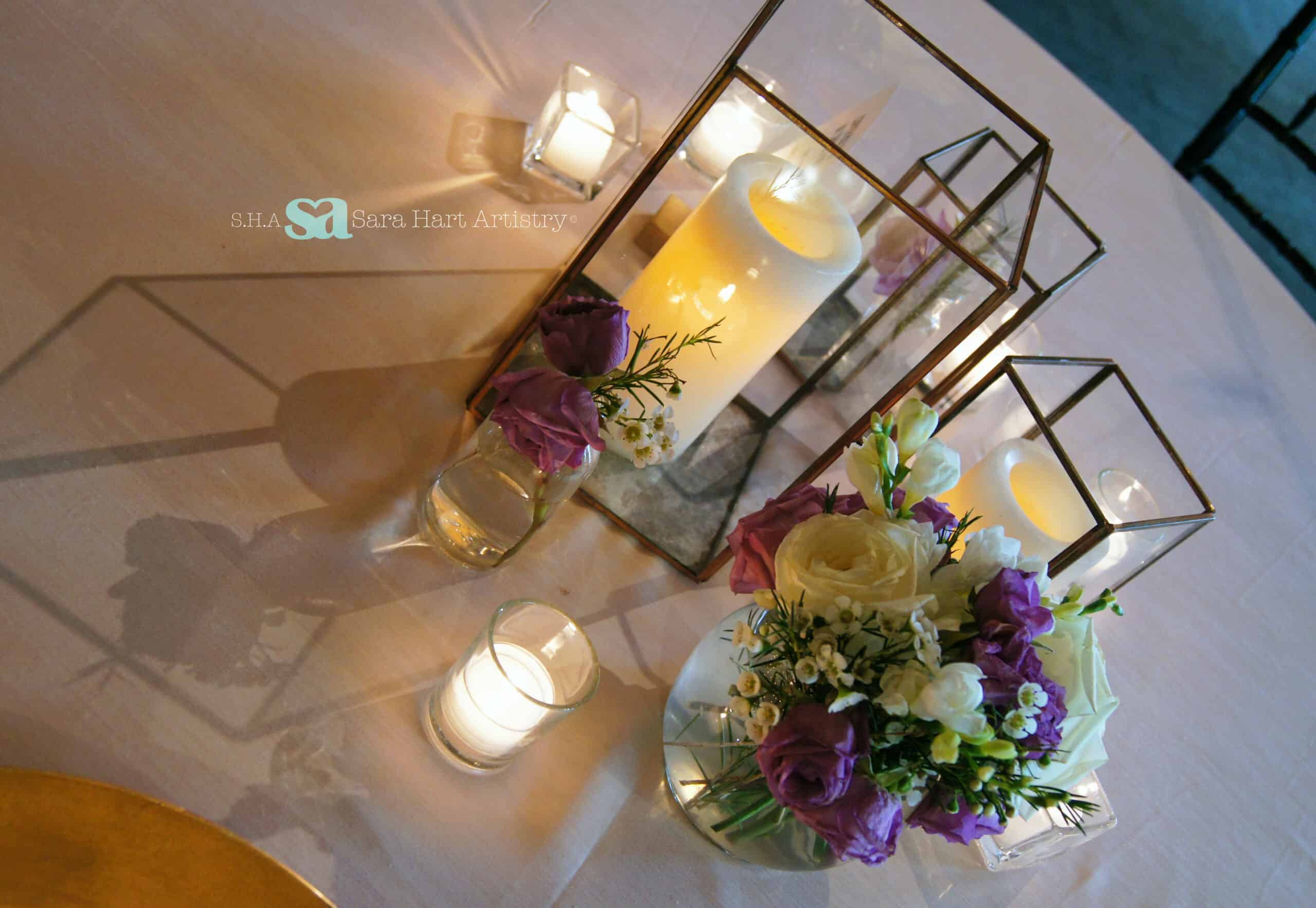 Decorative floral arrangement with candles for wedding or event decor.