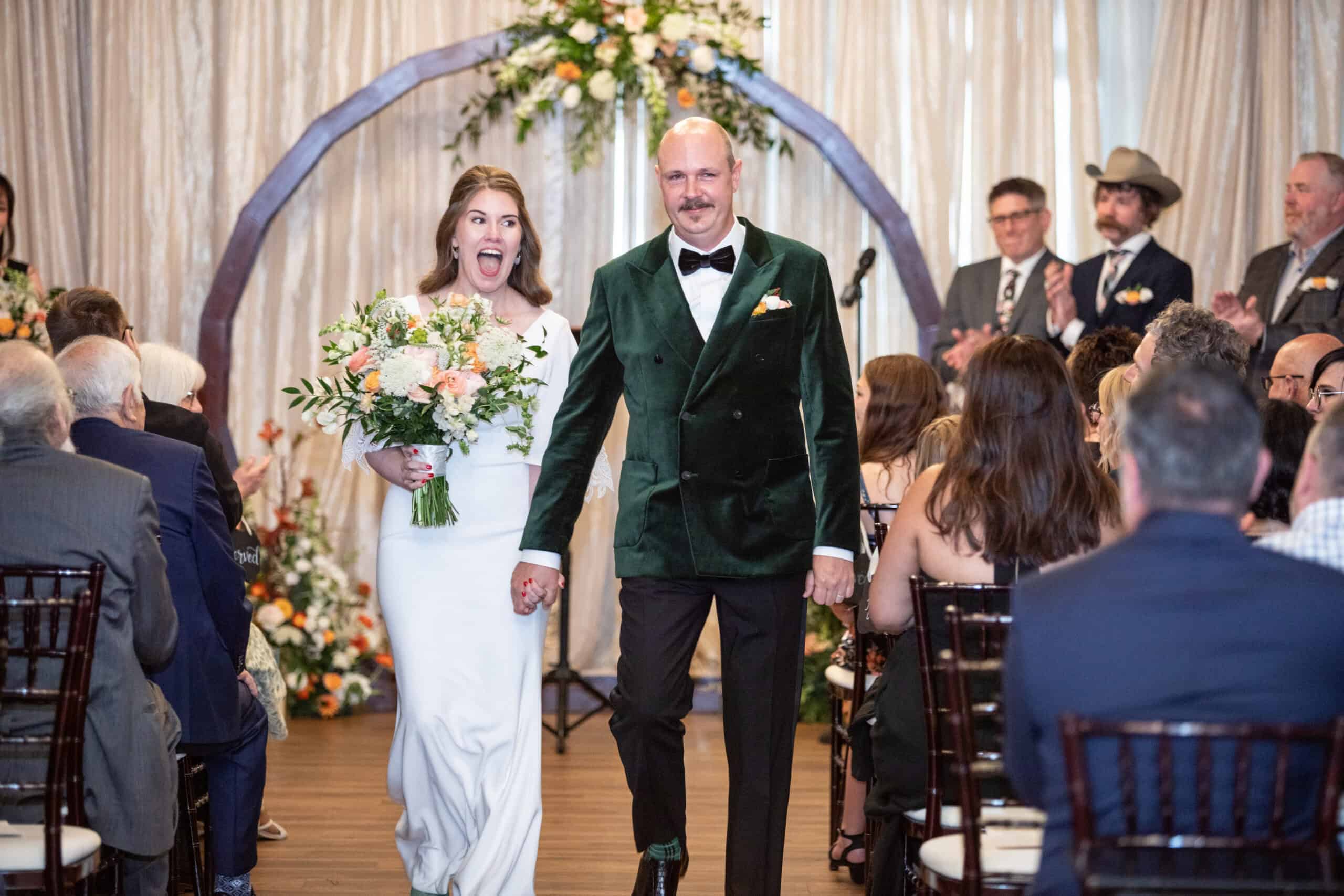 Bride and groom walking down the aisle at a wedding.