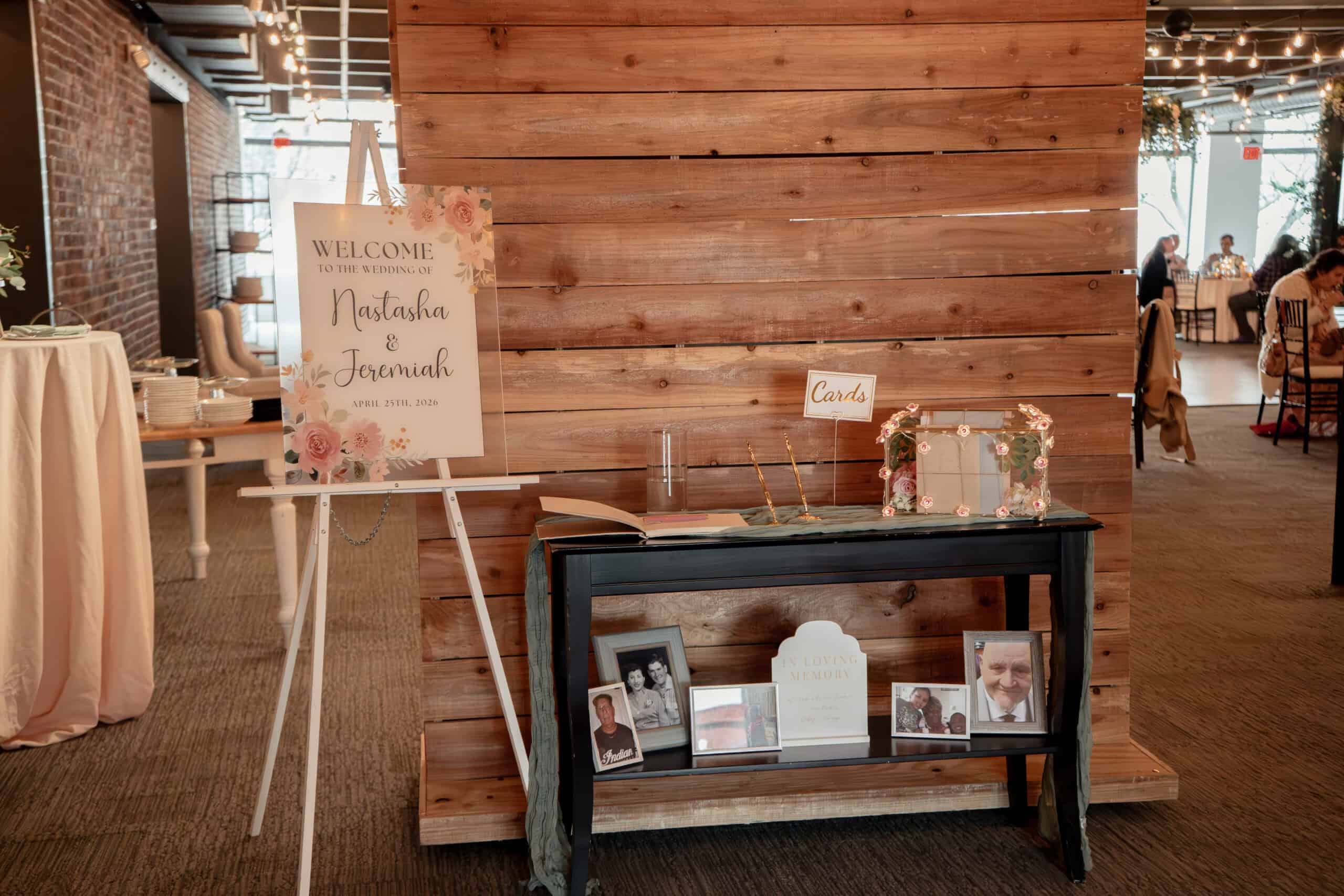 Wedding welcome table with floral sign and framed photos at Sky Armory.