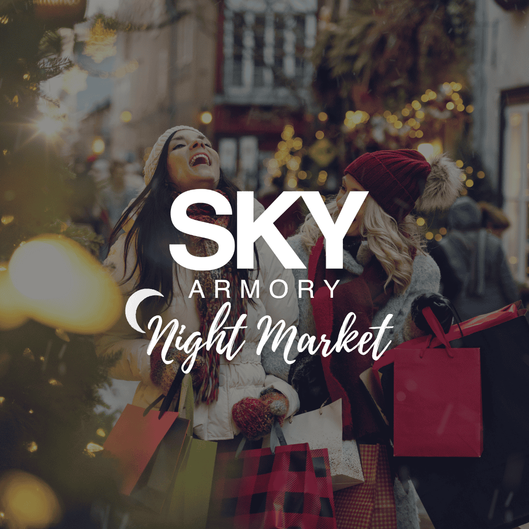 People shopping at SKY Armory night market with holiday lights and decorations.
