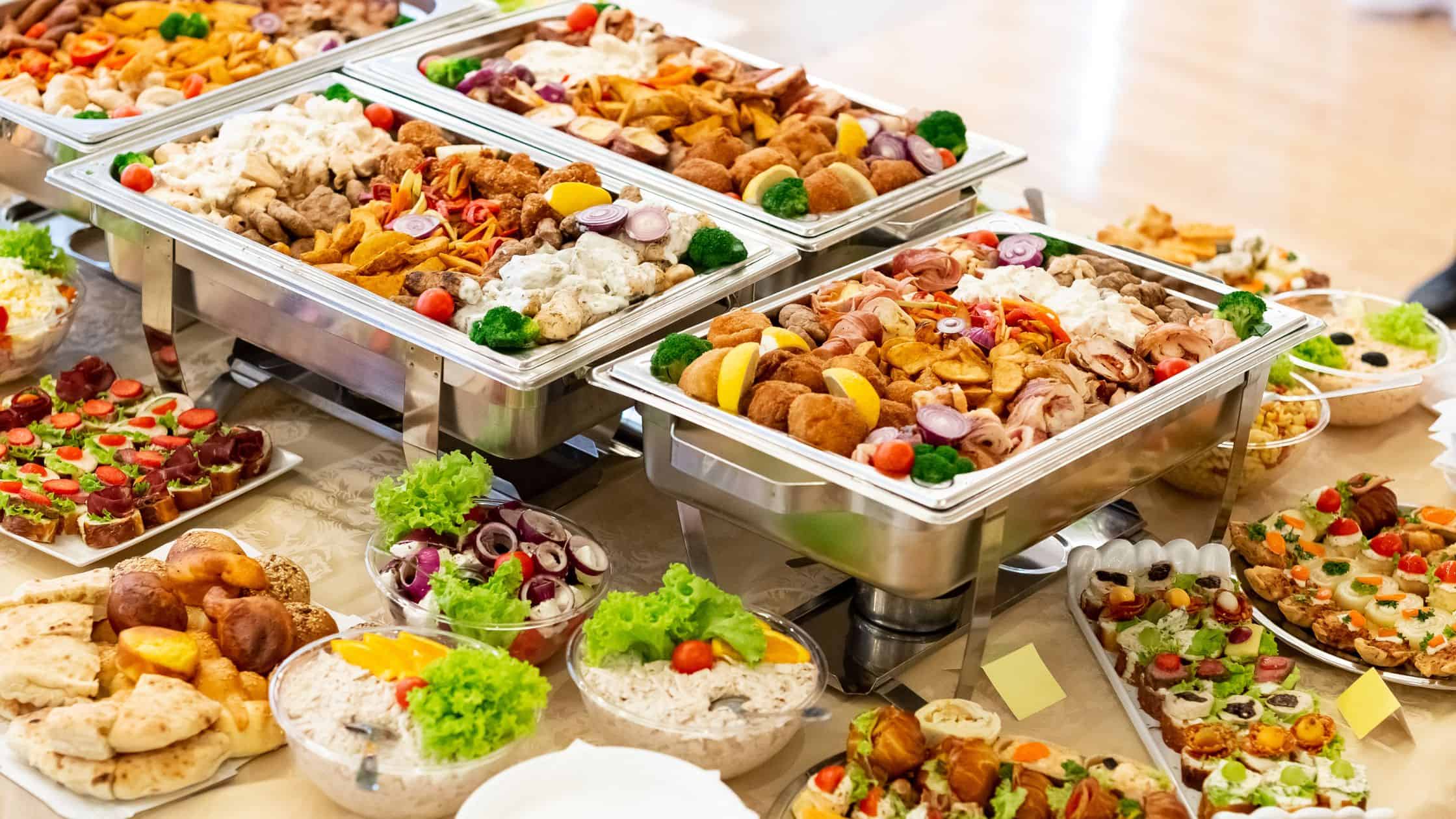 Assorted catering dishes including salads, meats, and appetizers for events.