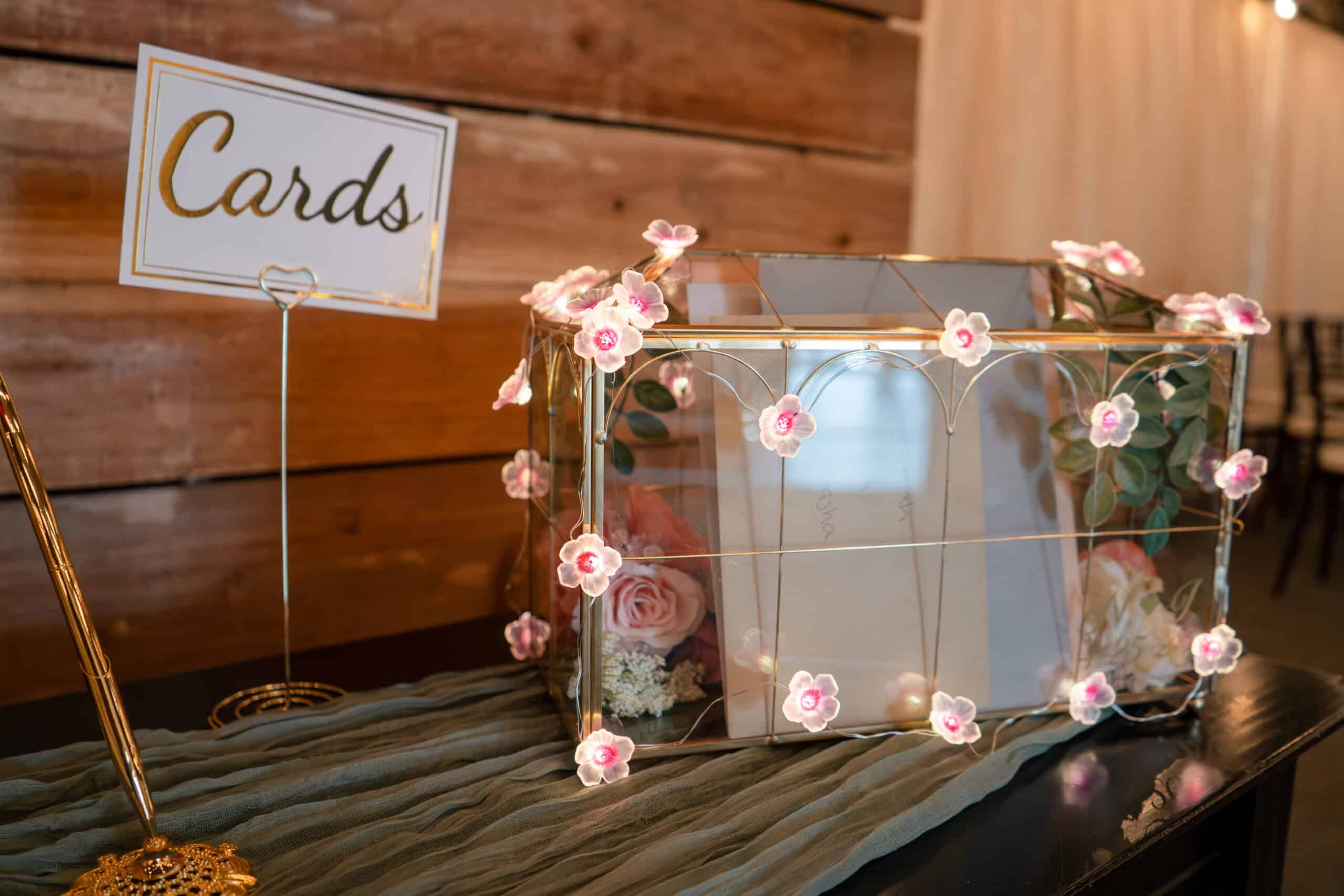 Elegant glass box with pink flowers for wedding or event decor.