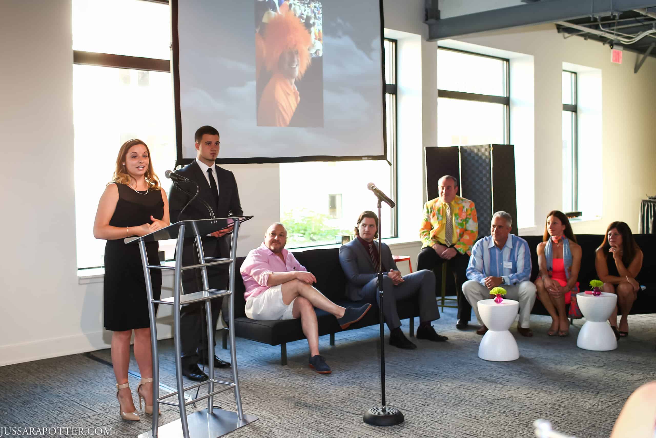 Business presentation at Sky Armory with speakers and audience.