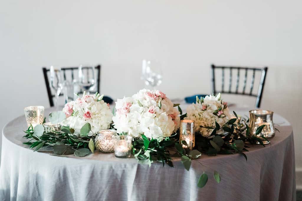 Beautiful wedding table with floral centerpiece and candles.