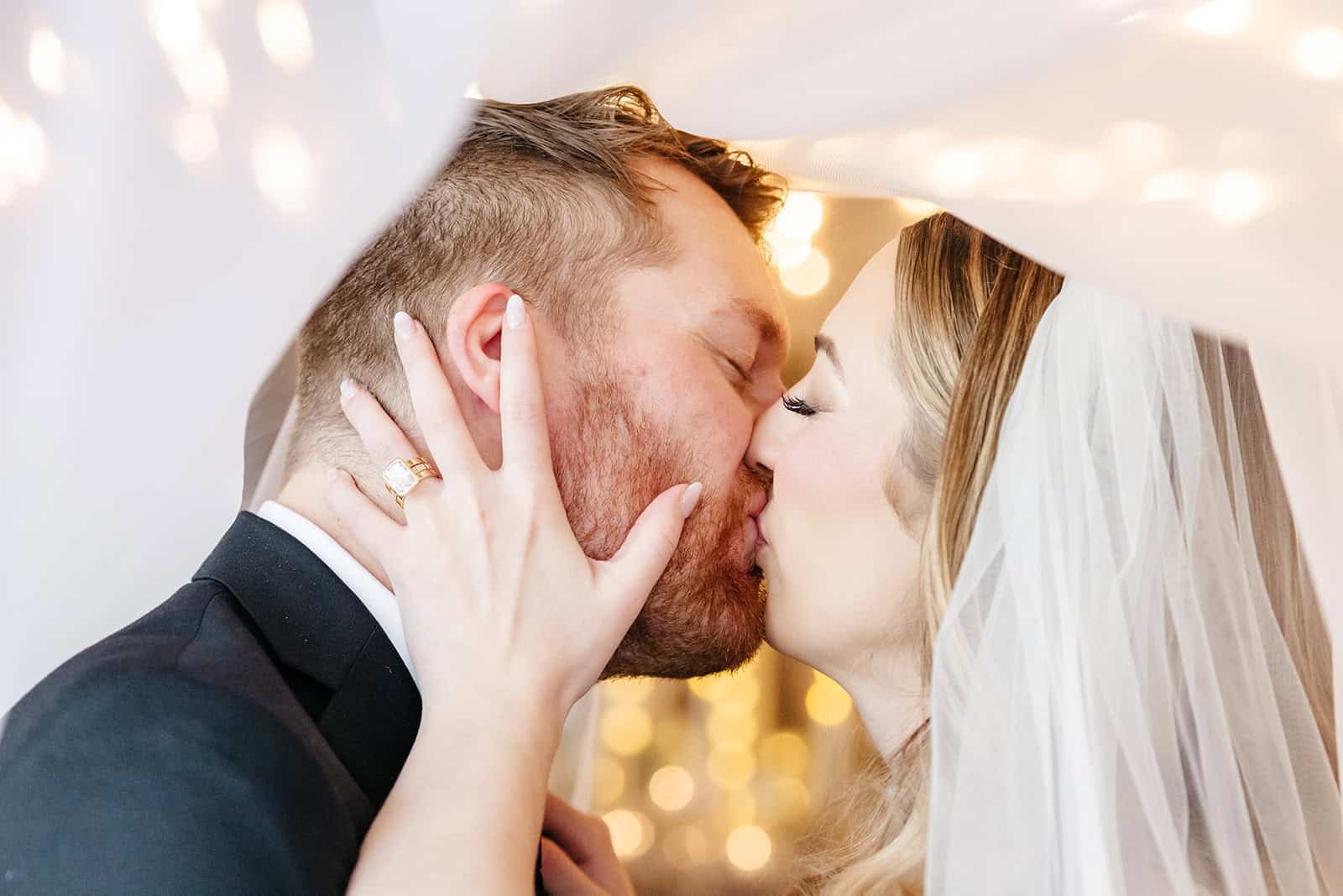 Bride and groom sharing a kiss during wedding celebration in Armory Square.