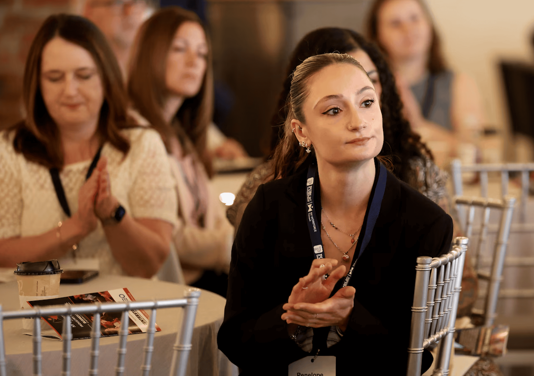 Attentive woman at SKY Armory conference listening intently.