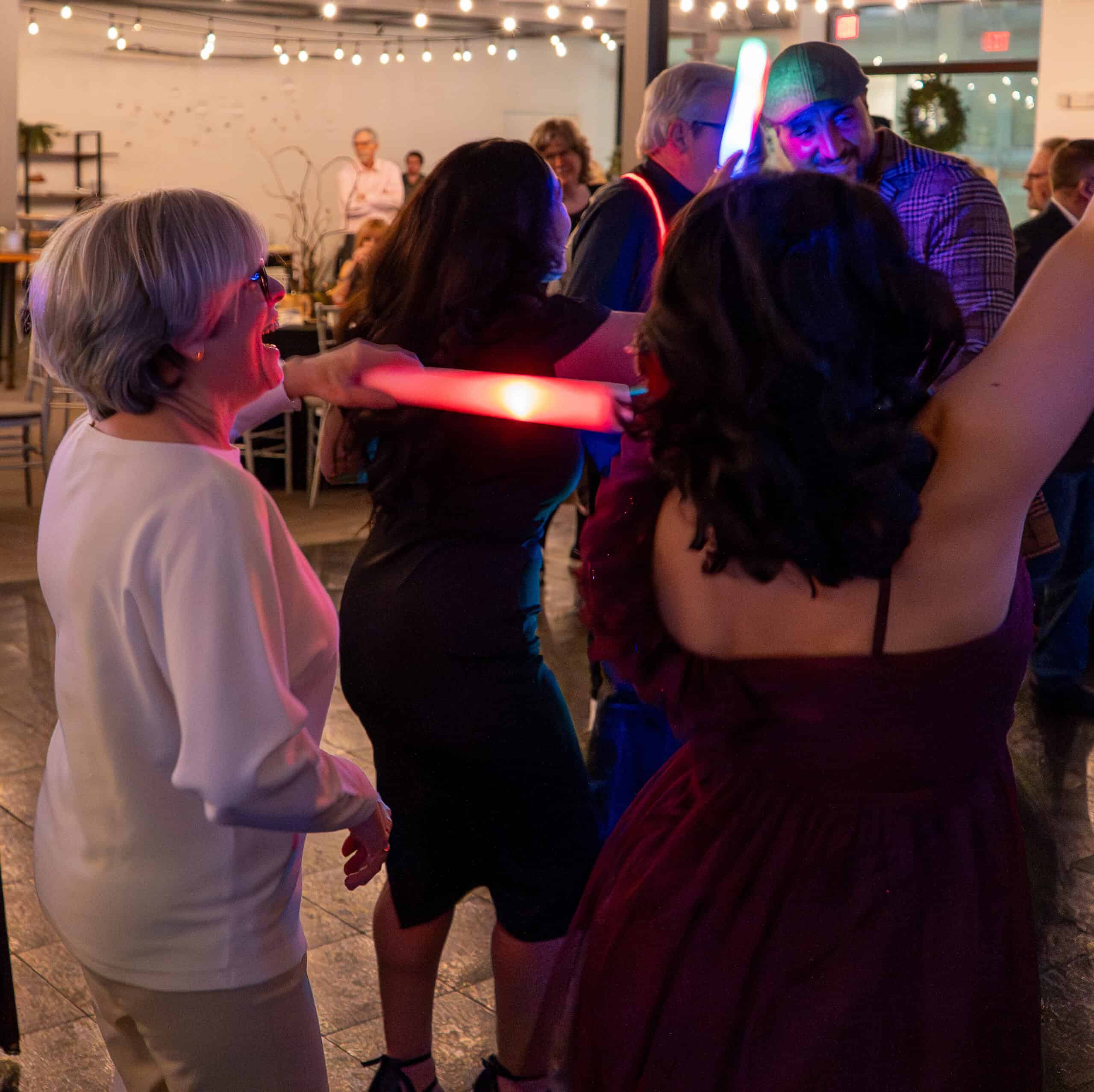 People enjoying a night event with laser lights at SKY Armory venue.