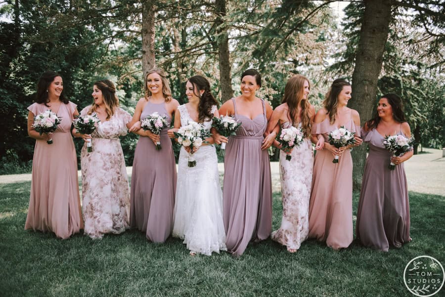Bridesmaids in pastel dresses holding bouquets at SKY Armory spring wedding.