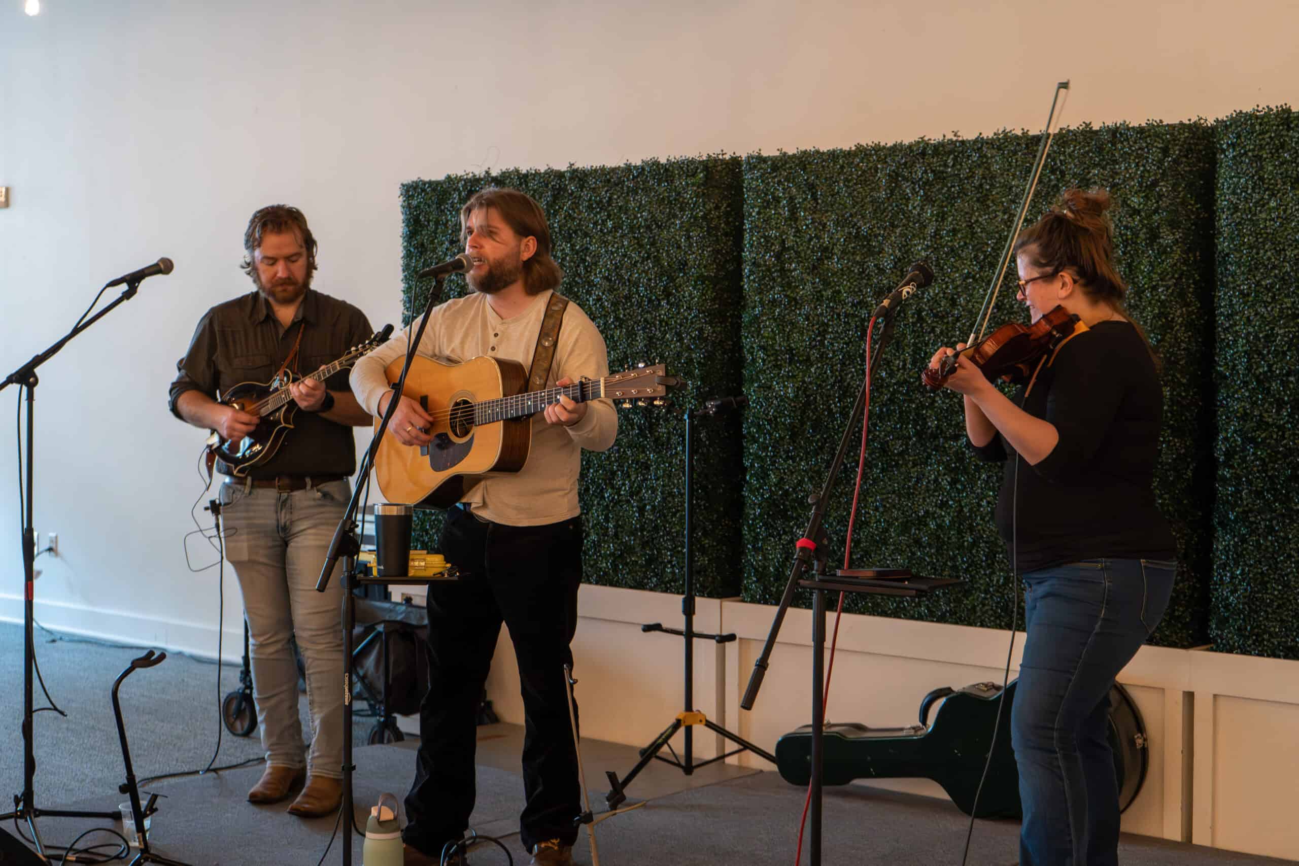 Musicians performing live with guitars and violin at SKY Armory event.
