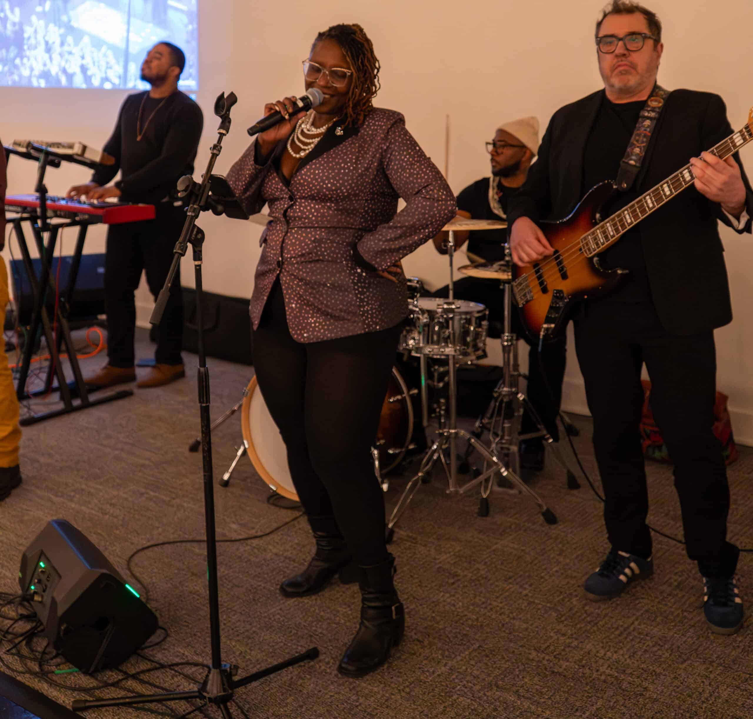 Band performing live music at SKY Armory event with singer and instrumentalists.