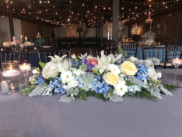 Beautiful floral centerpiece with candles at SKY Armory wedding venue.