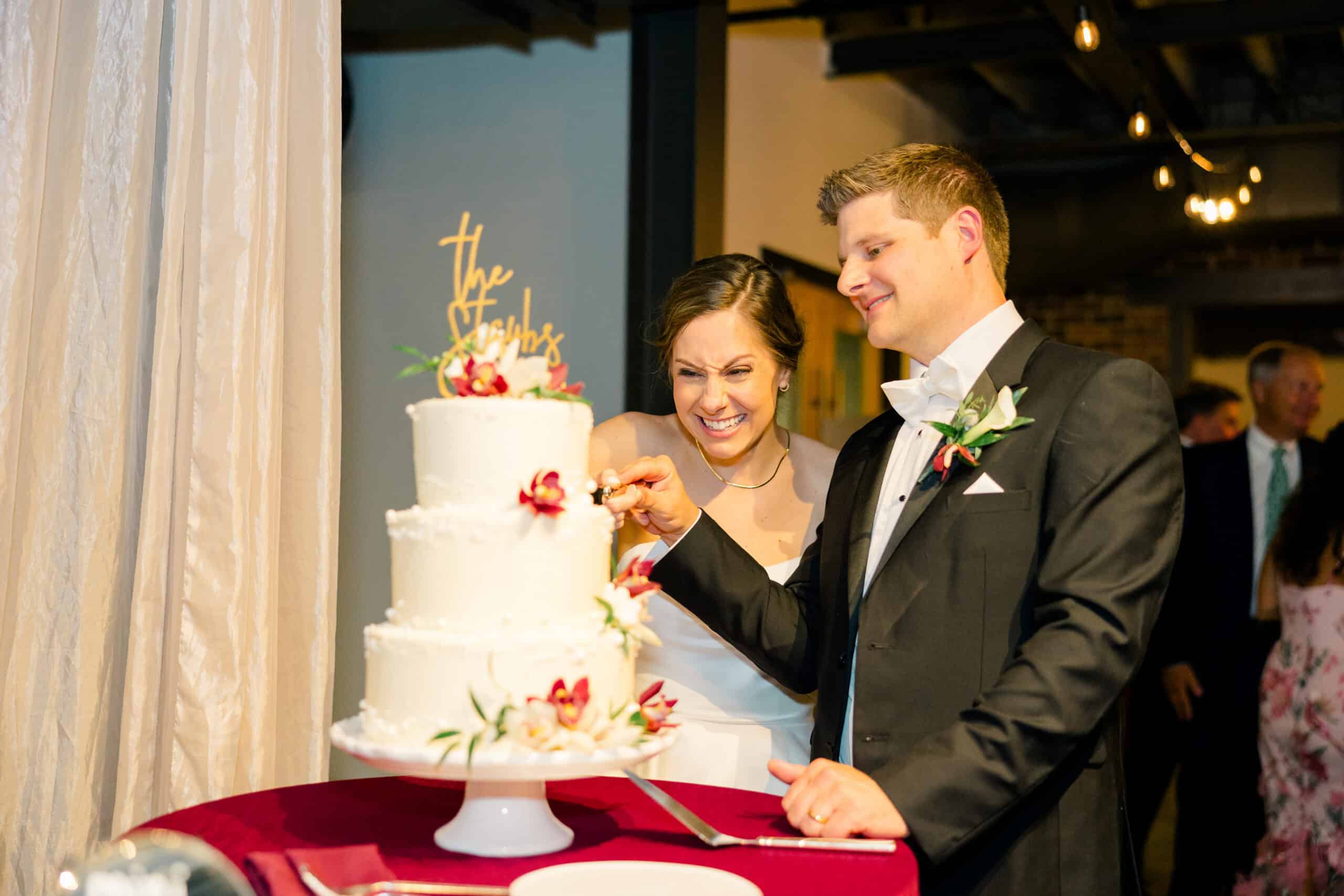 Bride and groom cutting wedding cake at reception.