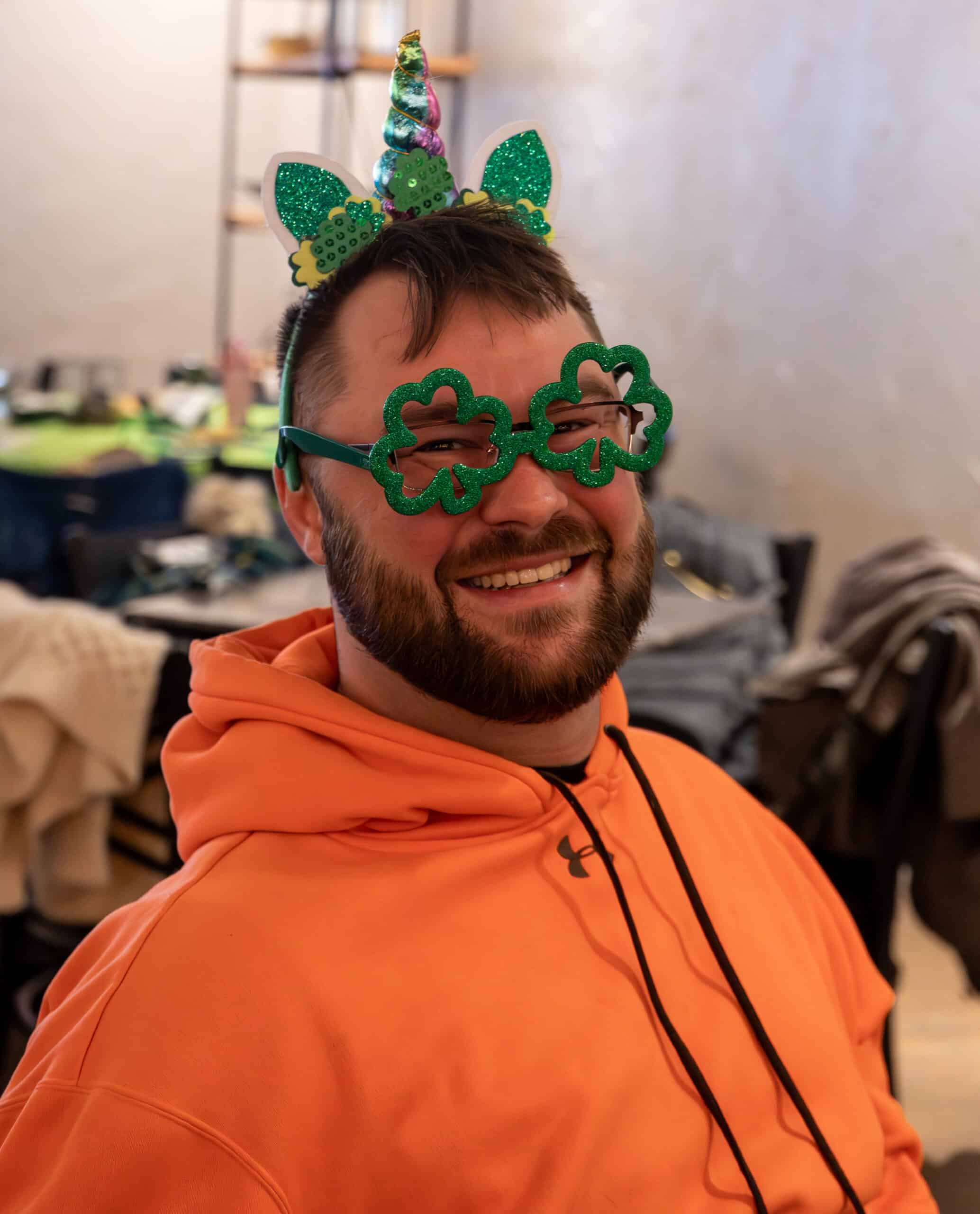Man wearing green unicorn headband and glasses for a fun celebration.