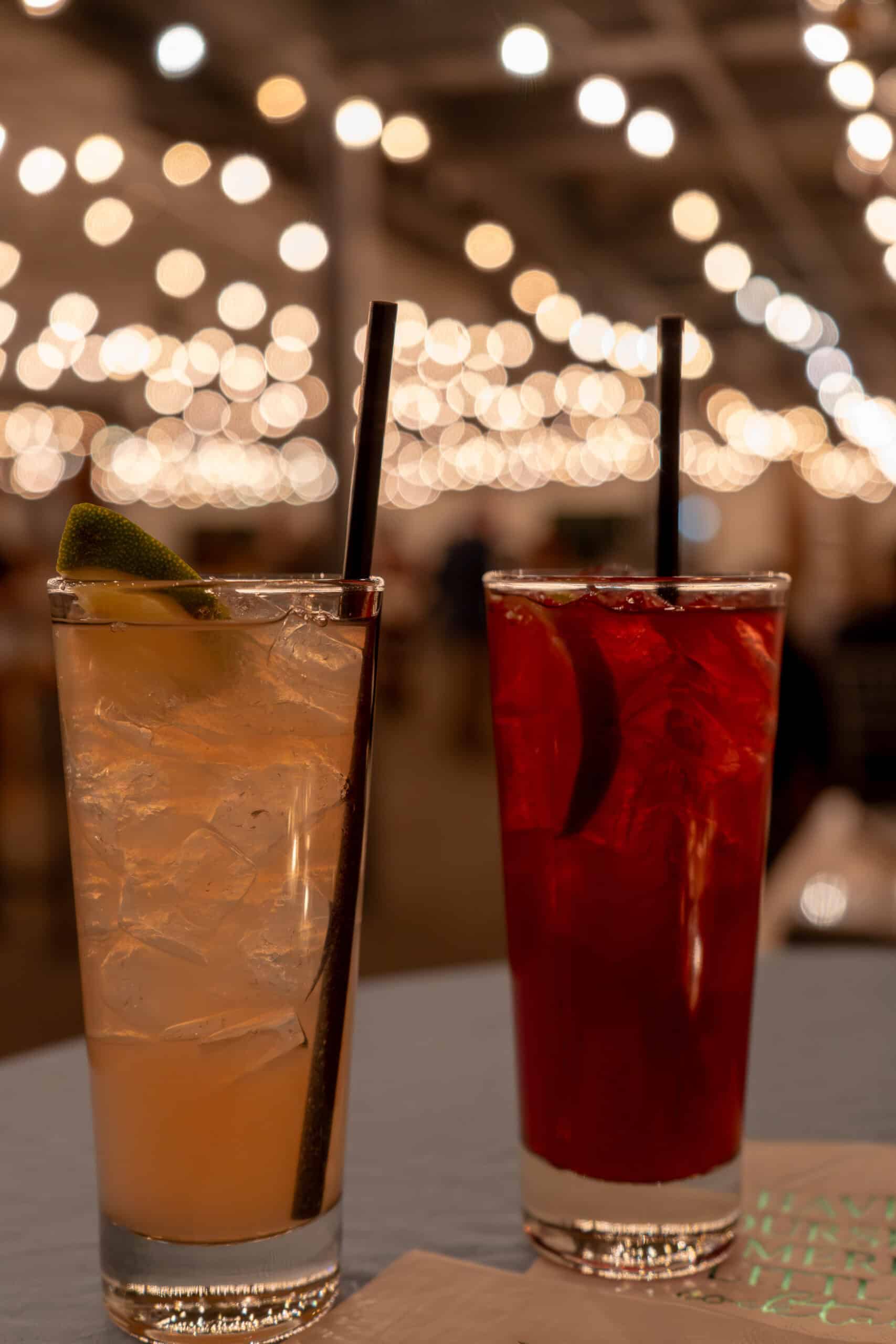 Two colorful cocktails with ice and straws at SKY Armory bar.