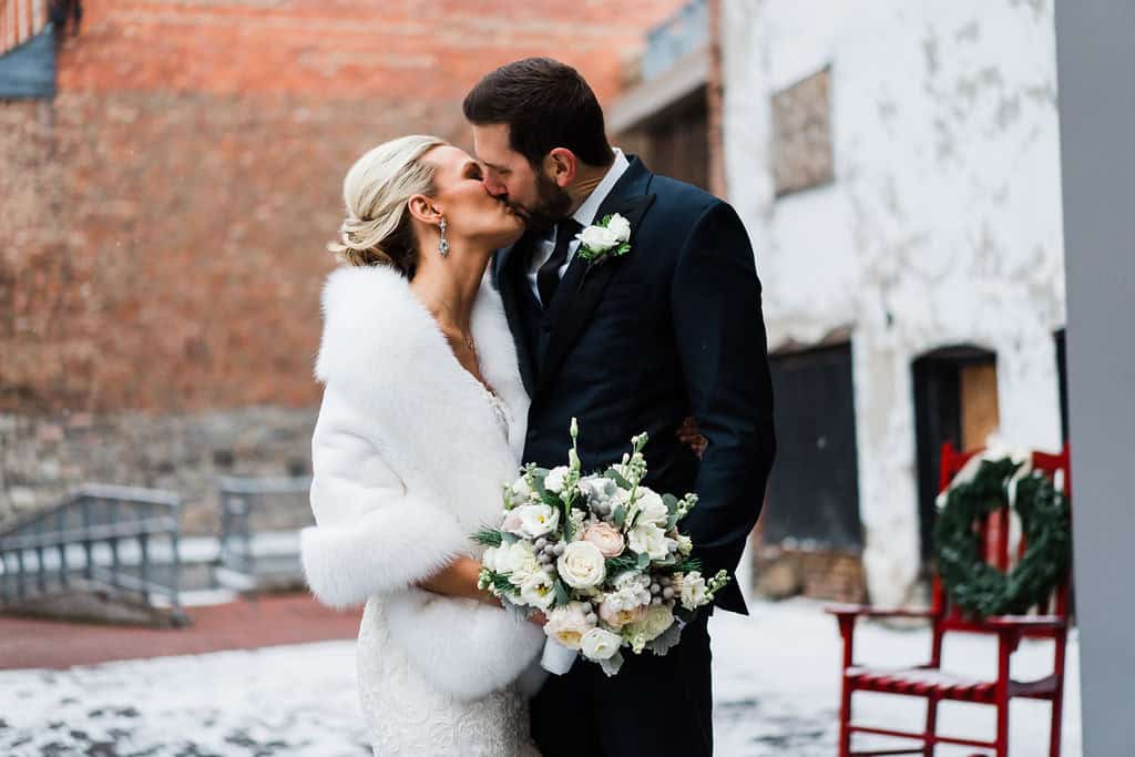 Bride and groom sharing a kiss outdoors in winter at SKY Armory.