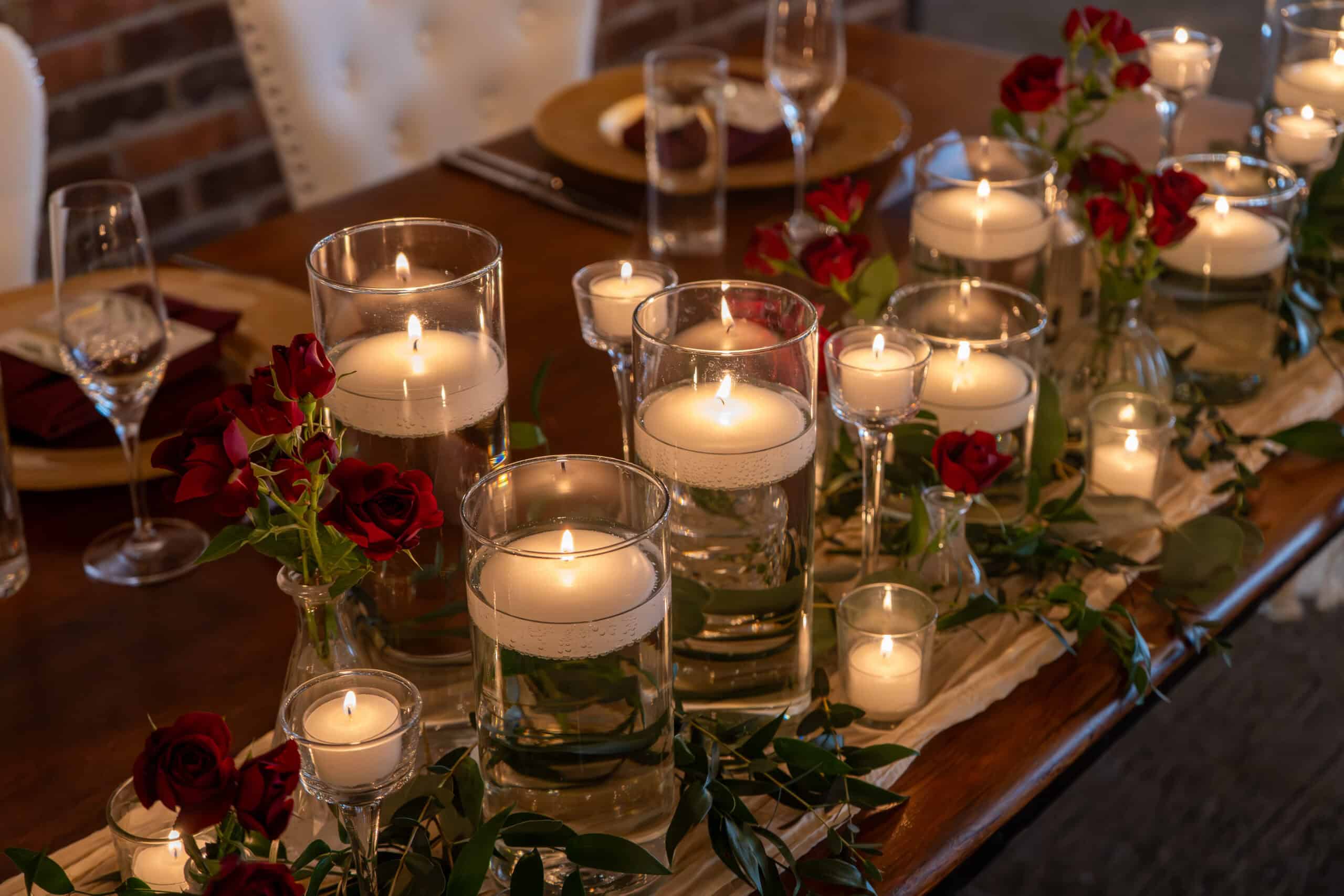 Decorative table with candles and red roses for special event.
