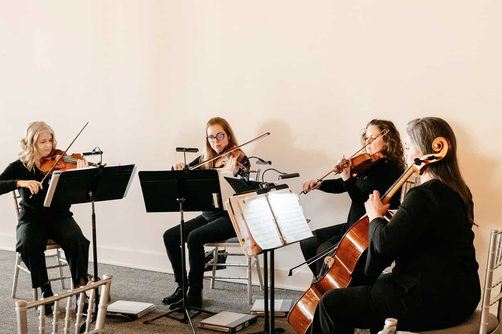 String quartet performing live with violins and cello in a concert setting.