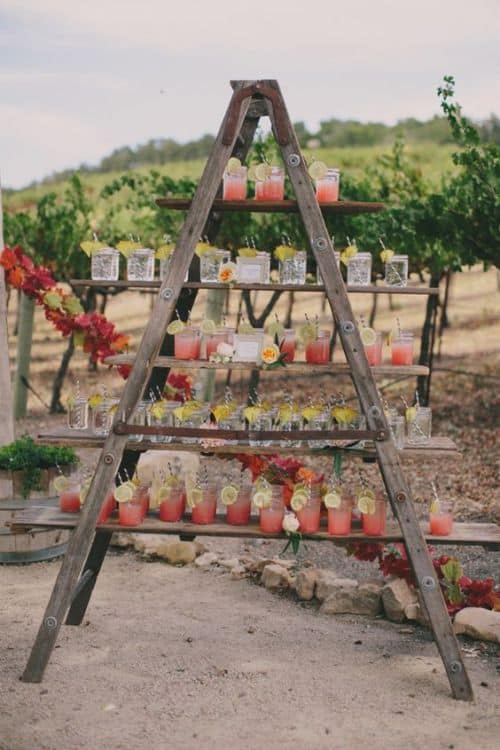 Lemonade drinks on a rustic wooden ladder at a summer wedding.