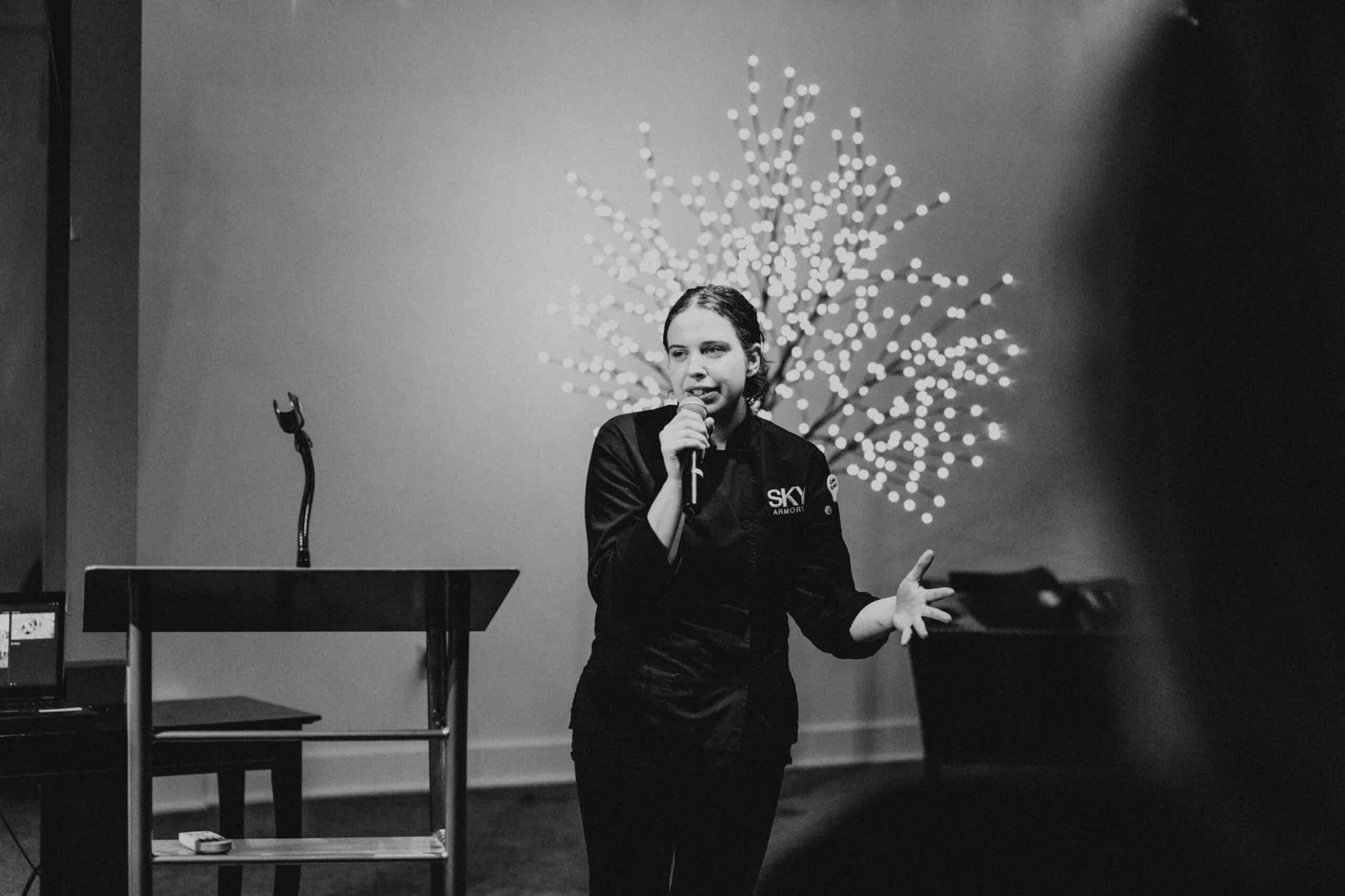 Female chef speaking at SKY Armory during Syracuse Chef Challenge.