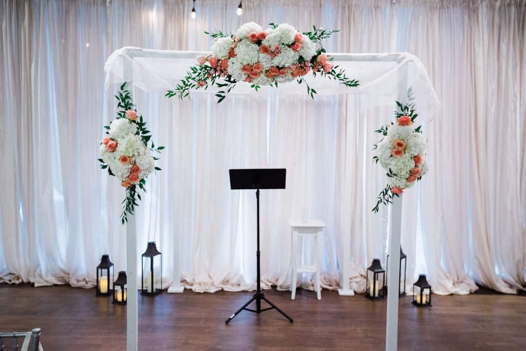 Beautiful wedding arch decorated with white and peach flowers for a romantic ceremony.