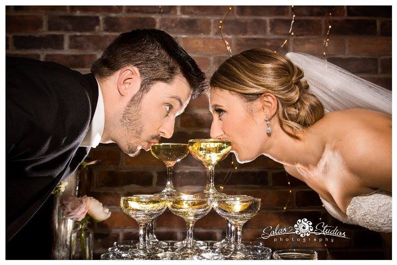 Bride and groom toast with champagne glasses at SKY Armory micro wedding.