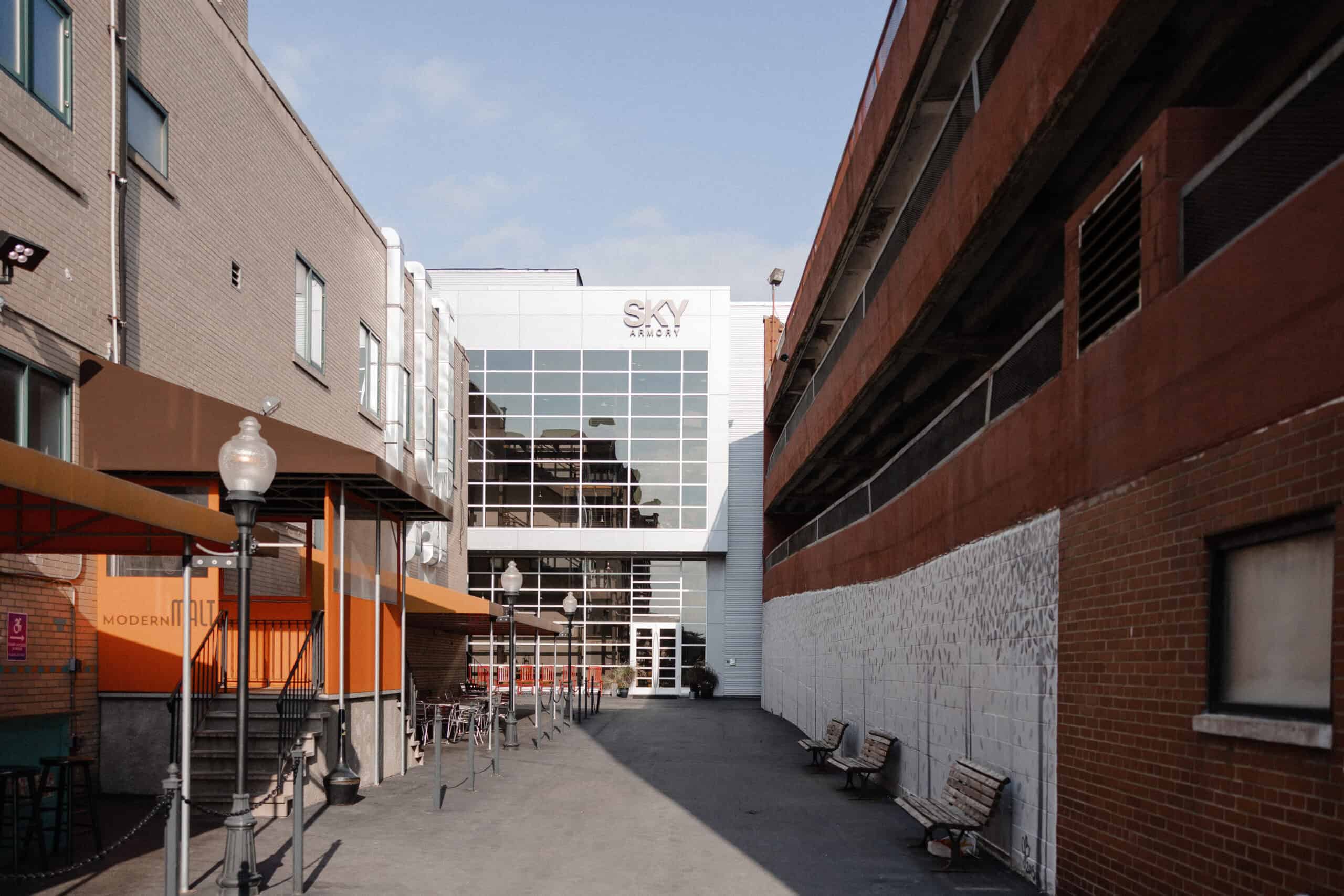 Exterior view of SKY Armory venue with modern architecture and outdoor seating area.