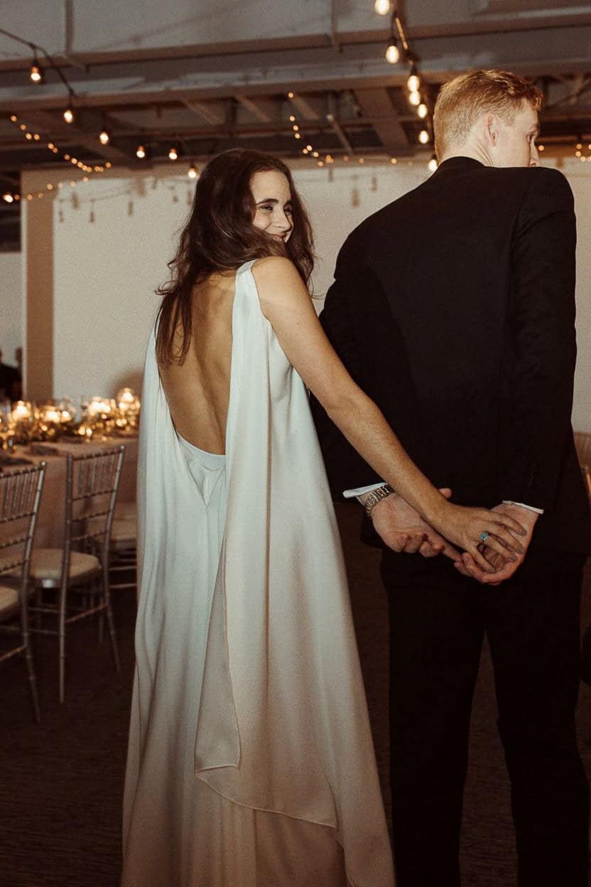 Couple dancing at SKY Armory wedding reception, woman in white dress, man in black suit.